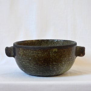 以下が含まれることがあります： 2つの取っ手が付いた緑と茶色の陶器のボウル。ボウルは斑点のある釉薬と濃い茶色の縁を持っています。