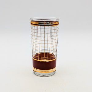 May include: A tall, clear glass with a gold grid pattern and a maroon band around the middle. The glass has the word "CULVER" printed on the maroon band.