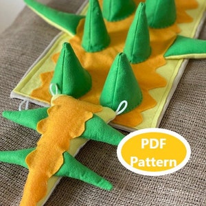 Könnte beinhalten: Ein PDF-Muster für ein Filz-Dinosaurierspielzeug. Das Muster enthält Anweisungen zum Herstellen eines grünen und gelben Dinosauriers mit Stacheln und einem Schwanz.