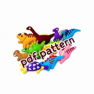 May include: A collection of colorful felt dinosaur shapes in various colors including orange, green, blue, purple, and pink, featuring stitched details and patterns, with the text pdf pattern overlaid across the center of the group of figures.