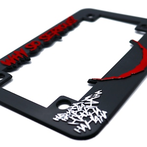 May include: Black plastic license plate frame with a red and white Joker design. The frame features the text "Why So Serious?" and a red Joker smile.