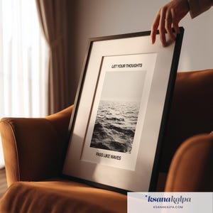 May include: A black framed wall art print featuring a monochrome photograph of ocean waves. The text LET YOUR THOUGHTS is printed above the image and PASS LIKE WAVES is printed below the image in a clean, black sans-serif font.