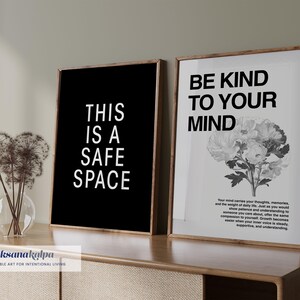 May include: Two framed prints with inspirational quotes. One has the text "THIS IS A SAFE SPACE" on a black background. The other says "BE KIND TO YOUR MIND" with a floral illustration. Both are in wooden frames.