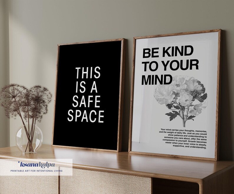 May include: Two framed prints with inspirational quotes. One has the text "THIS IS A SAFE SPACE" on a black background. The other says "BE KIND TO YOUR MIND" with a floral illustration. Both are in wooden frames.