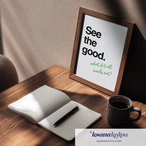 May include: A framed print featuring the black text See the good. and the green text what if it all works out? displayed in a brown wooden frame next to an open notebook with a black pen and a dark brown ceramic mug of coffee.