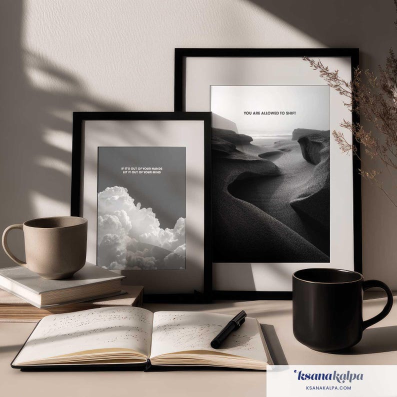 May include: Two black-framed wall art prints featuring monochrome landscapes and clouds with the text IF IT'S OUT OF YOUR HANDS LET IT OUT OF YOUR MIND and YOU ARE ALLOWED TO SHIFT, accompanied by two ceramic mugs, a stack of books, and an open notebook.