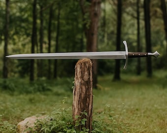 May include: A long, silver sword with a dark brown handle and a decorative pommel is displayed outdoors. The sword is resting on a tree stump, with a forest background. The blade is approximately 40 inches long.