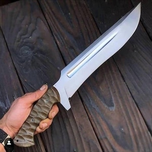 Puede incluir: Un cuchillo grande, plateado, con un mango de patrón marrón y negro. La hoja es afilada y tiene una ligera curva.