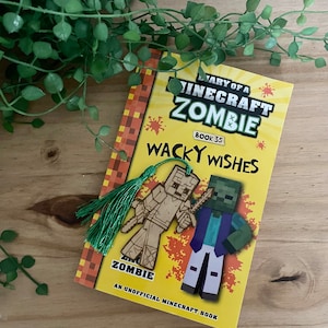 May include: A yellow book with a green and brown bookmark. The book cover features a Minecraft zombie character and the title "Diary of a Minecraft Zombie: Wacky Wishes, Book 35". An unofficial Minecraft book.