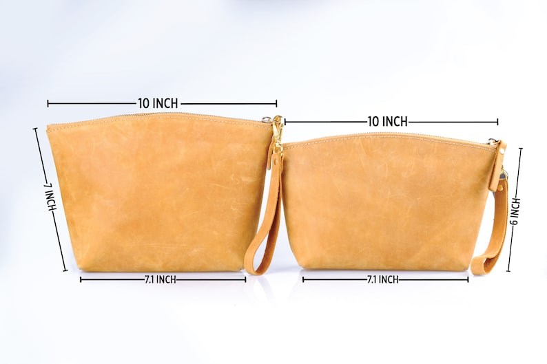 Puede incluir: Dos estuches de cremallera de cuero marr&oacute;n con herrajes dorados. El estuche m&aacute;s grande mide 25,4 cm de ancho, 17,8 cm de alto y 18 cm de profundidad. El estuche m&aacute;s peque&ntilde;o mide 25,4 cm de ancho, 15,2 cm de alto y 18 cm de profundidad.