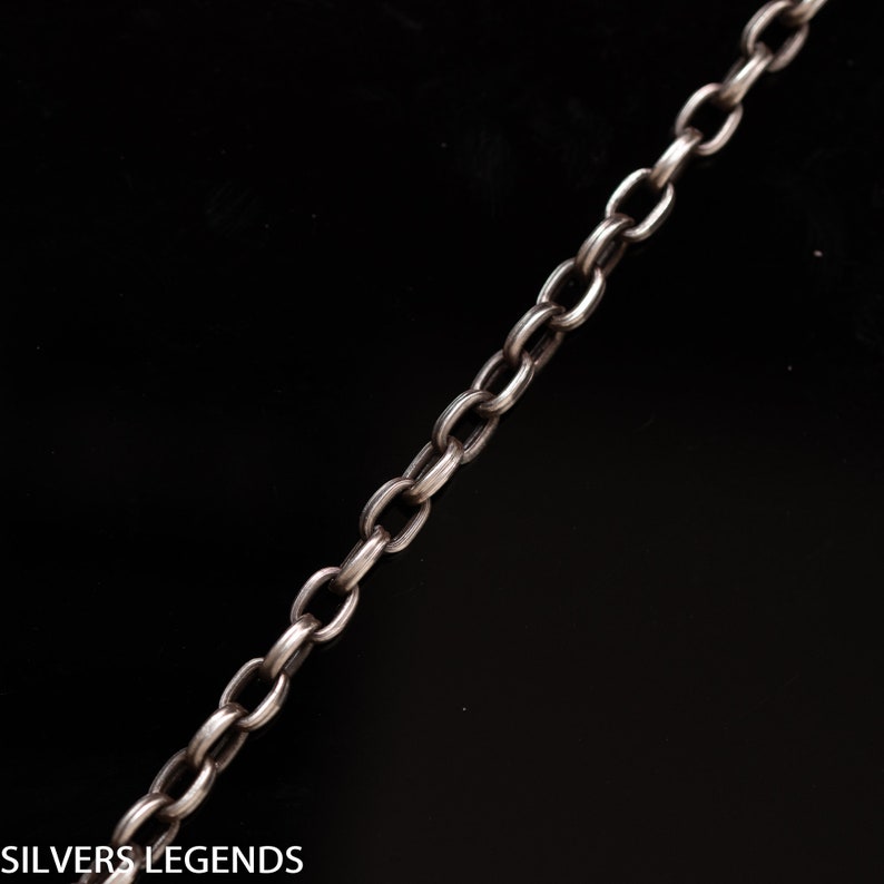 May include: A silver chain necklace with a simple, classic design. The chain is made of small, oval-shaped links.