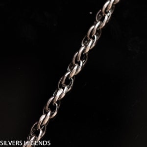 May include: A silver chain necklace with a curb link design. The chain is made of metal and has a shiny finish.