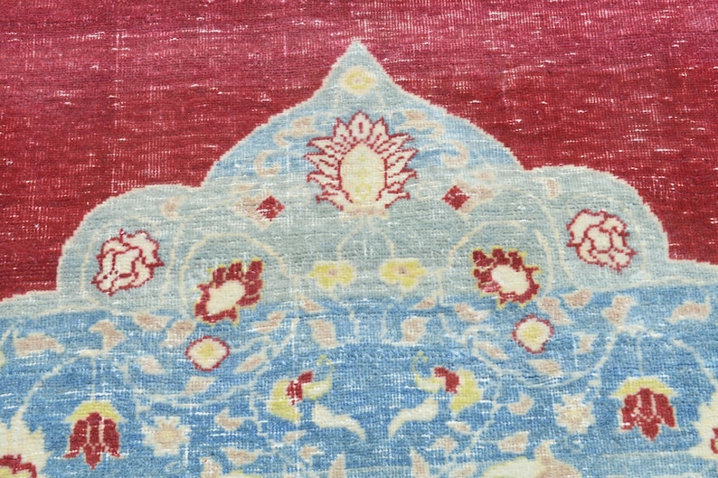 May include: A vintage rug with a red center and a blue and white floral pattern. The rug has a traditional design with a central medallion and a border.