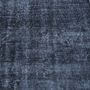 May include: A rectangular area rug featuring a deep black and charcoal gray color palette with a distressed, weathered texture. The surface displays a dense, woven grid pattern with visible signs of wear, creating a mottled appearance across the fabric.