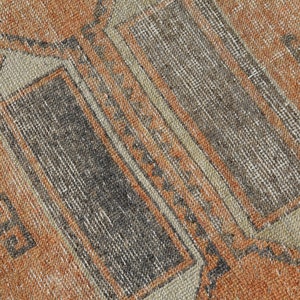 K&ouml;nnte beinhalten: Nahaufnahme eines Vintage-Teppichs mit einem geometrischen Muster in Braun-, Beige- und Oranget&ouml;nen.