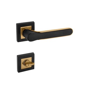 Op de afbeelding: Zwarte en gouden deurknop met een vierkante rozet en een hendel. De knop is gemaakt van metaal en heeft een geborstelde afwerking.