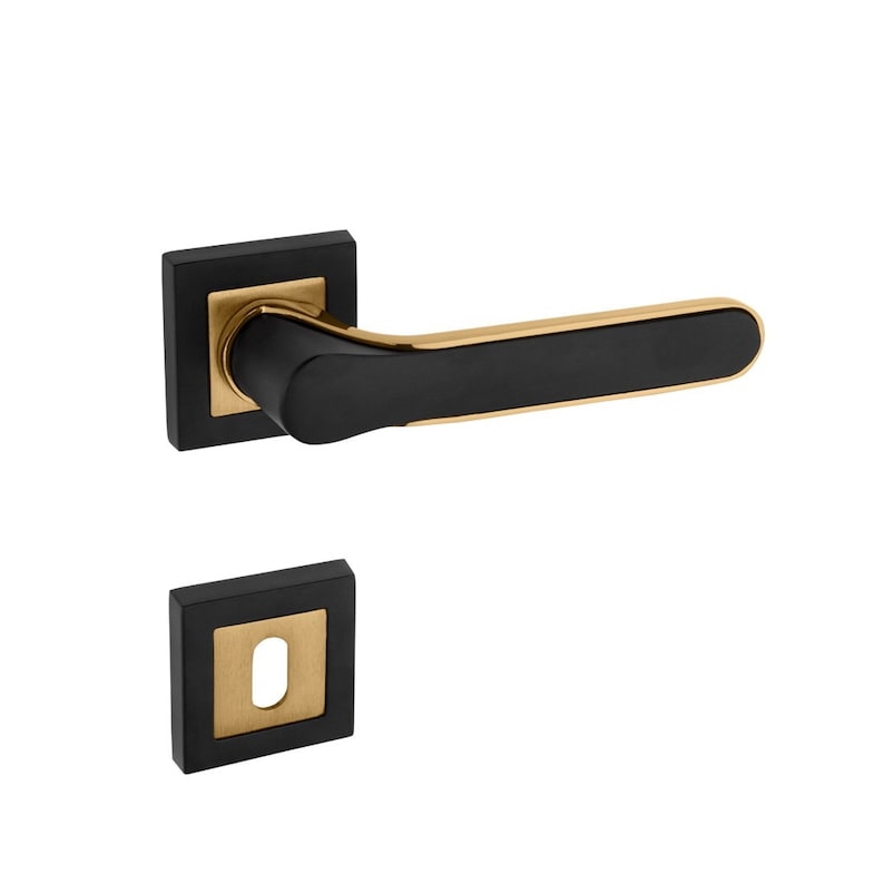 Op de afbeelding: Zwarte en gouden deurknop met een vierkante rozet en een sleutelgat. De knop is van metaal en heeft een modern ontwerp.