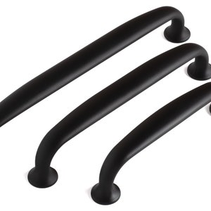 May include: Three matte black cabinet pulls arranged in a diagonal row. Each handle features a smooth, arched design with two circular mounting bases at the ends. The hardware has a consistent dark finish and a curved, ergonomic shape for gripping.
