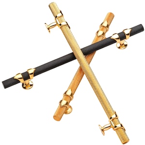 May include: Two cabinet door pulls, one gold and one black, with a textured finish. Both pulls have a decorative design at each end.