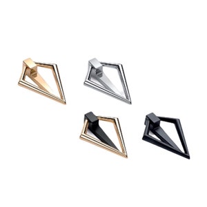 Könnte beinhalten: Vier moderne Schrankgriffe in Gold, Silber, Schwarz und einer Kombination aus Gold und Schwarz. Jeder Griff hat eine geometrische Raute mit einem dreieckigen Griff. Die Hardware ist für Schubladen oder Schränke konzipiert.