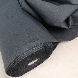 May include: A roll of black fabric with a smooth, woven texture. The fabric is rolled tightly and is ready to be used for sewing or crafting projects.