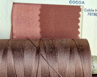 May include: A spool of brown thread next to a fabric swatch labeled "COCOA" with the cable number "70192".