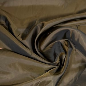 May include: A close-up of a smooth, dark brown fabric with a silky sheen. The fabric is folded and draped, showcasing its texture and drape.