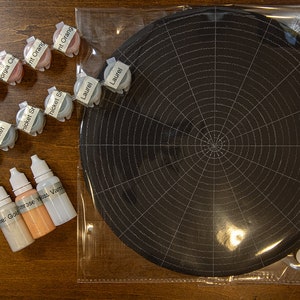 Könnte beinhalten: Ein Set mit Malutensilien zum Basteln, darunter kleine Gläser mit Farbe, die mit Namen wie "Thicket", "Laurel" und "Orange" beschriftet sind, sowie drei Flaschen mit Farbe, die mit "Goldest", "24k" und "Varnish" beschriftet sind.