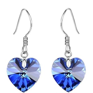 Puede incluir: Un par de pendientes de plata en forma de corazón con detalles de cristal azul.