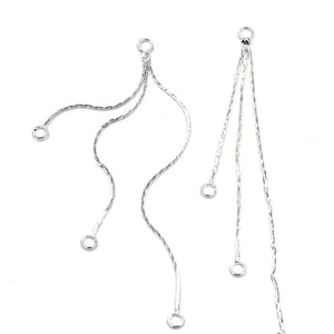 Puede incluir: Dos extensores de pendientes de cadena plateada con múltiples bucles. Cada extensor tiene un solo bucle en la parte superior y múltiples bucles que cuelgan.