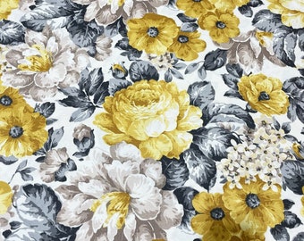 May include: Floral fabric featuring a pattern of large yellow and white flowers, grey leaves, and smaller yellow blossoms on a white backdrop. The flowers have detailed petals and are closely arranged.