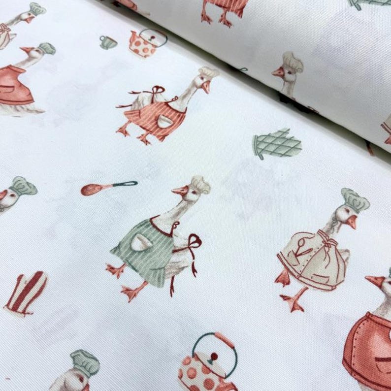 May include: White fabric with a repeating pattern of geese wearing chef hats and aprons. The geese are holding kitchen utensils and there are also images of teapots and other kitchen items.