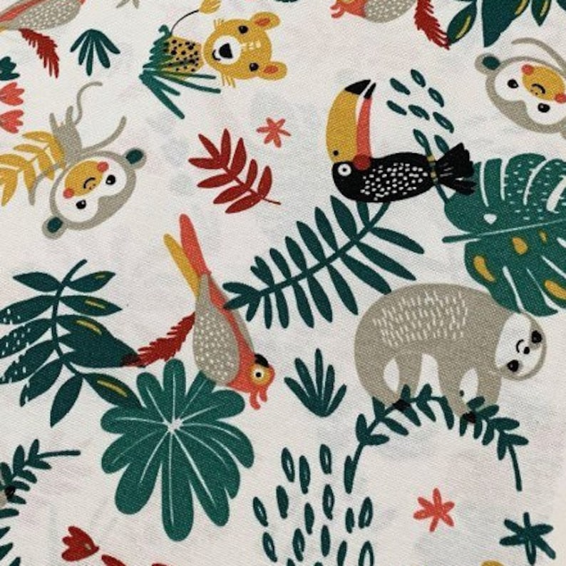 May include: White fabric with a repeating pattern of jungle animals and plants. The animals include a toucan, a sloth, a monkey, and a leopard. The plants are green and red.