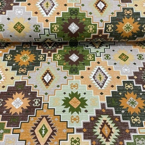 May include: A fabric with a geometric pattern in shades of brown, green, orange, and white. The pattern features repeating diamond shapes and stars.