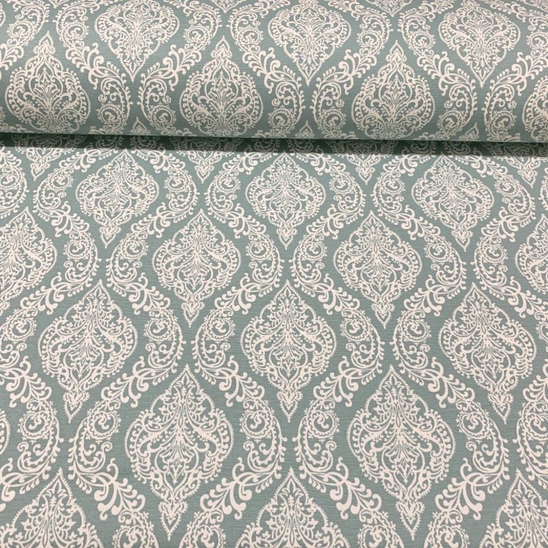 May include: A teal fabric with a white damask pattern. The fabric has a subtle sheen and a soft texture.