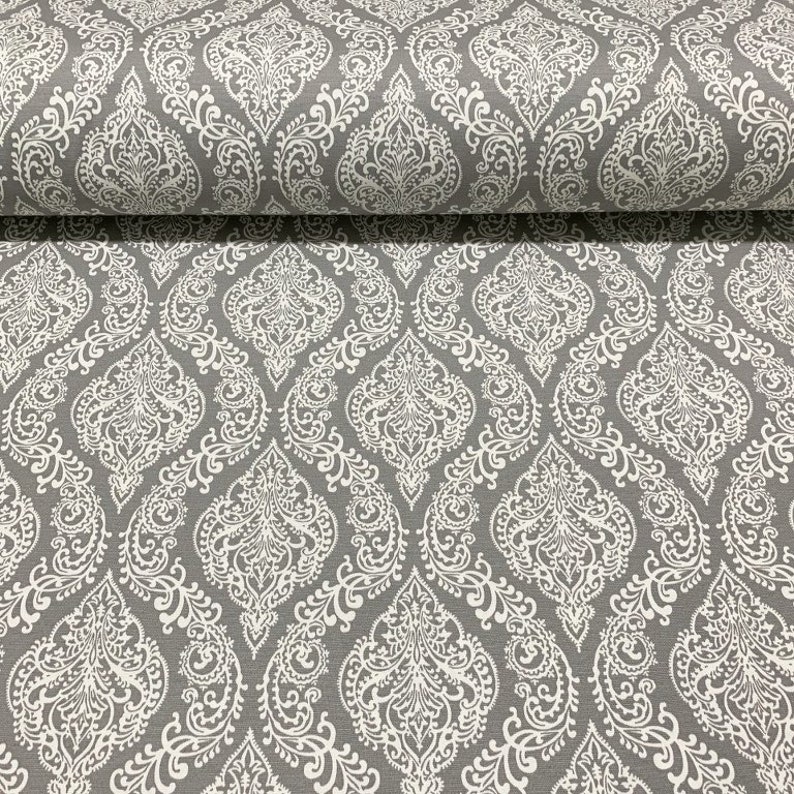 May include: Gray fabric with a white damask pattern. The pattern features intricate floral designs.