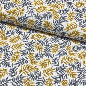 May include: Close-up of a white fabric featuring a repeating pattern of gold and grey stylized leaves. The leaves are densely arranged, creating a textured effect. The fabric is likely cotton or a similar material, suitable for various craft projects.