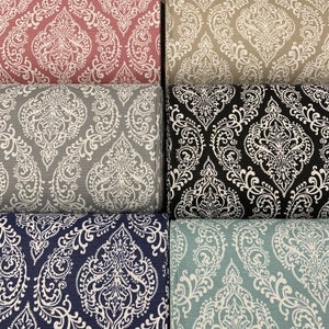 May include: Five fabric swatches with a white damask pattern on different colored backgrounds. The colors are pink, beige, gray, navy blue, and light blue.