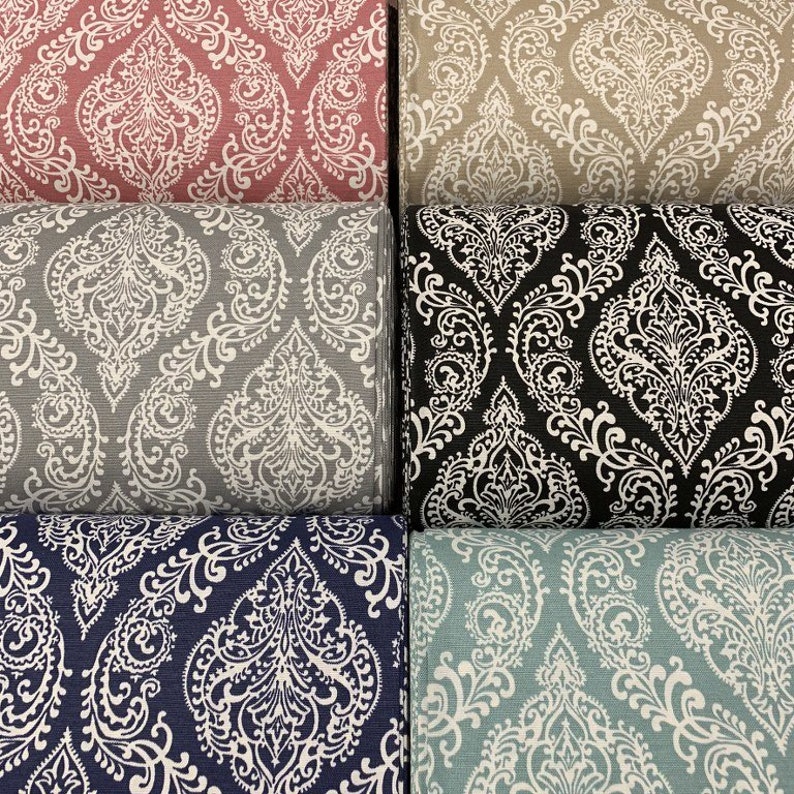 May include: Five fabric swatches with a white damask pattern on different colored backgrounds. The colors are pink, beige, gray, navy blue, and light blue.