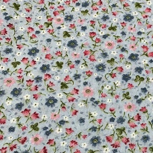 May include: A light blue fabric with a small-scale floral print. The print features pink, red, and blue flowers on a light blue background.
