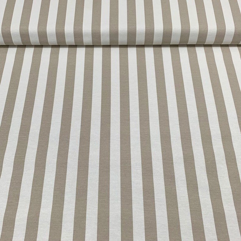 Op de afbeelding: Beige en wit gestreepte stof met een subtiele textuur. De stof is dubbelgevouwen, waardoor het patroon aan beide kanten zichtbaar is.