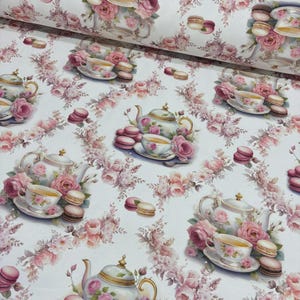 Puede incluir: Tela blanca con un patrón repetido de tazas de té, teteras, macarons y rosas rosas. El diseño presenta una estética vintage con colores suaves y arreglos florales. Ideal para manualidades o proyectos de decoración del hogar.