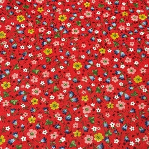 May include: Red fabric with a small floral print. The print features white, pink, blue, and yellow flowers.