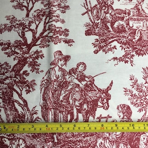 May include: White fabric featuring a burgundy toile de Jouy pattern. The design shows rural scenes with figures, trees, and animals. A yellow tape measure shows the fabric's length.
