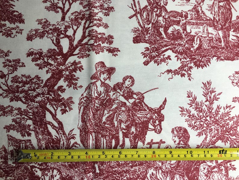 May include: White fabric featuring a burgundy toile de Jouy pattern. The design shows rural scenes with figures, trees, and animals. A yellow tape measure shows the fabric's length.