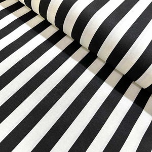 May include: Black and white striped fabric. The fabric is folded in half, showing the stripes running diagonally.