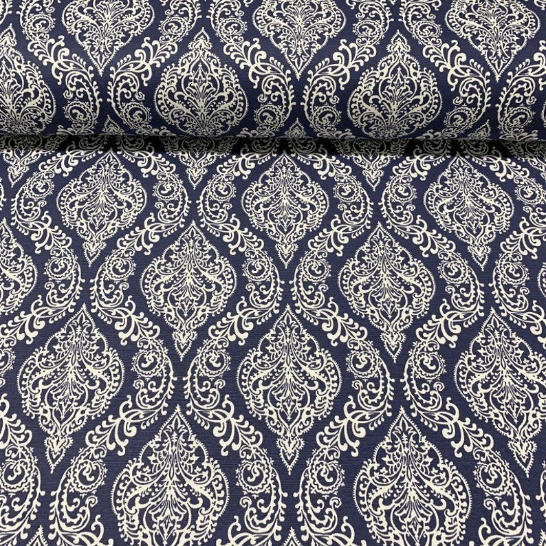 May include: A navy blue fabric with a white damask pattern. The fabric has a subtle texture and a repeating pattern of intricate floral designs.