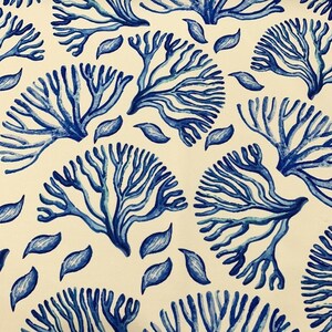 May include: A white fabric with a blue and white coral reef pattern. The coral is stylized and has a watercolor effect.