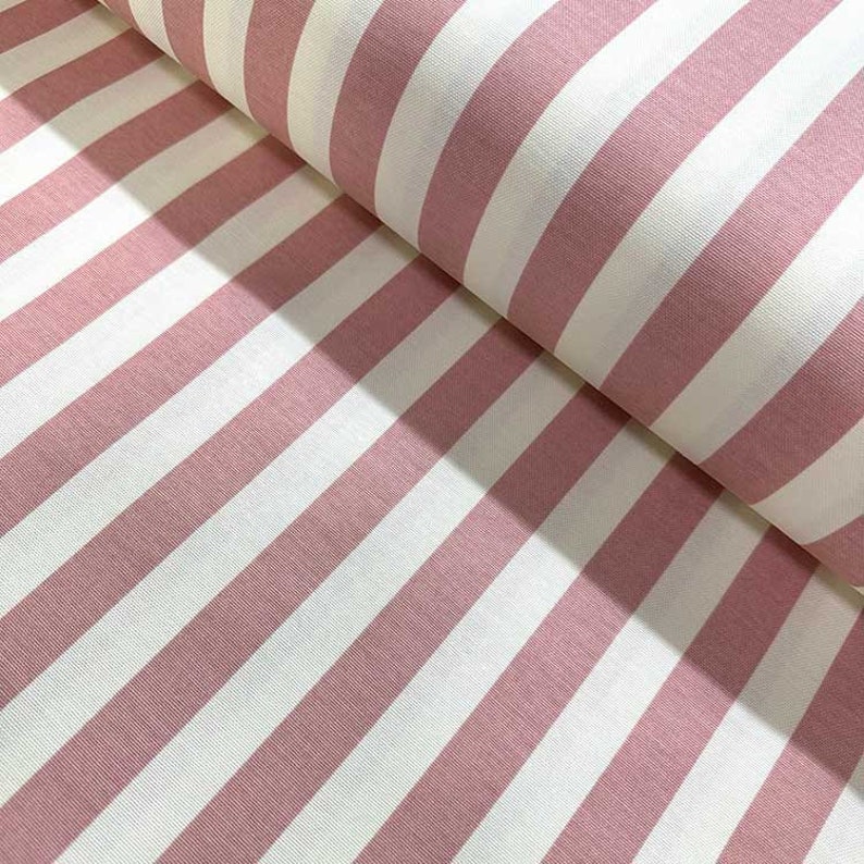 May include: Pink and white striped fabric. The fabric has a soft, cotton feel and is perfect for sewing projects.