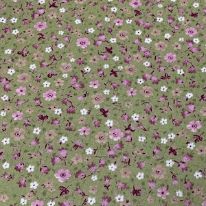 May include: A green fabric with a small pink and white floral pattern. The fabric is a light green color with a subtle texture.
